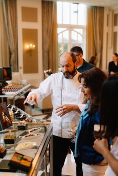 Chef preparing food at indoor station for guests.