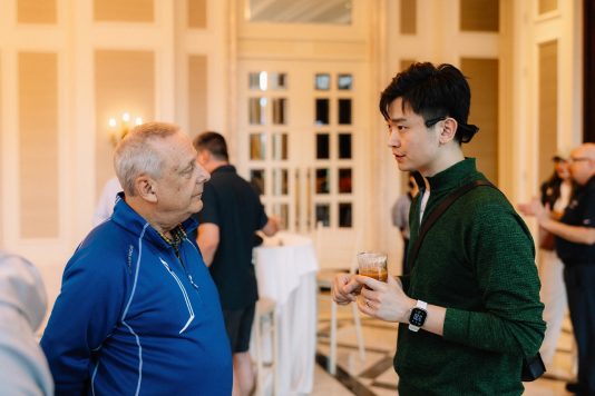 Guests conversing in a bright interior space.