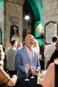 Guest standing and smiling during a reception.