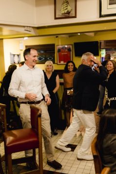 Guests laughing and conversing indoors.