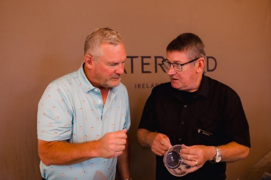 Two guests examining items at a Waterford display.