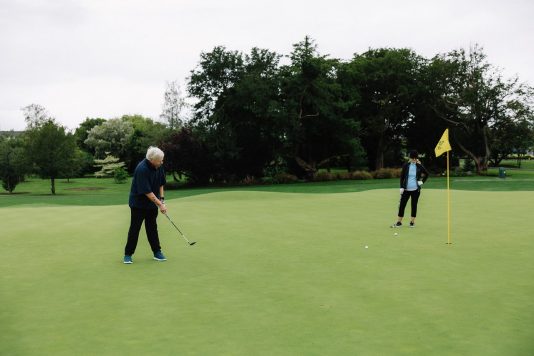 Golfer preparing a putt on the green.
