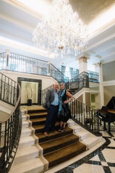 Two guests posing on a staircase indoors.
