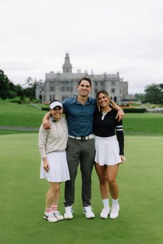 Three guests posing in front of the manor.
