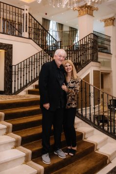 Two guests posing together on an indoor staircase.