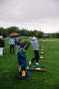Golfer practicing swings at the range.