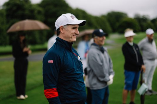 Guest standing on the course wearing a cap.