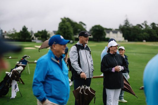 Group of golfers standing and watching.