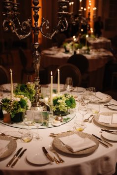 Candlelit dining table with floral centerpiece.