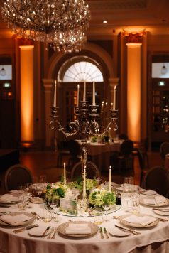 Candlelit dining table with ornate decor.