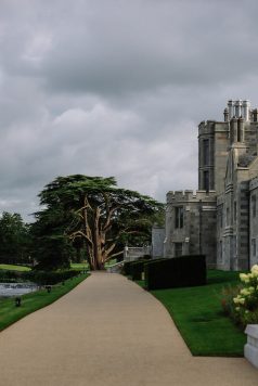 Exterior view of Adare Manor with trees.