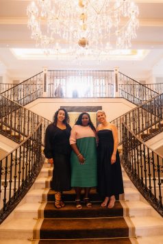 Group posing on a staircase landing indoors.