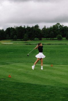 Golfer swinging a club on the course.