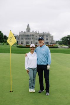 Guest standing near a golf hole and flag.