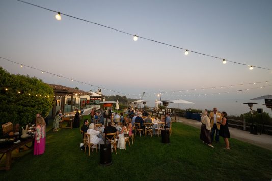 Guests dining outdoors at coastal reception