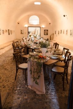 Long dining table inside an arched stone room