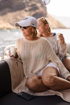 Guest seated on a boat near the coastline