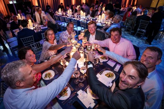 Guests raising glasses during dinner toast