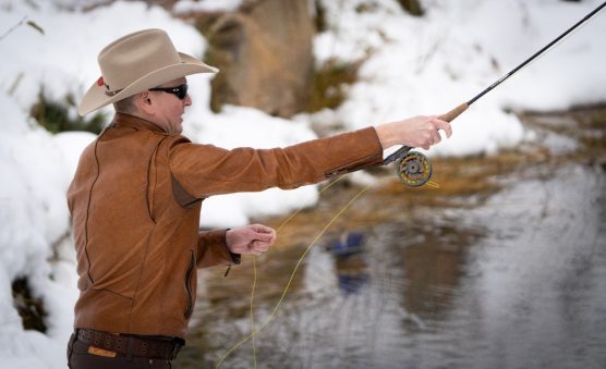 Guest fly fishing in snowy stream