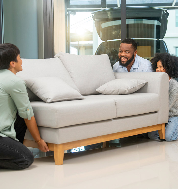 A family sets up their new couch in their home